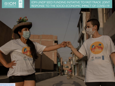 An image of two people wearing face masks and bumping fists